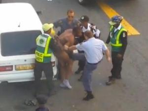 Screen grabs from a video posted to Facebook show police officers assaulting a naked man in Riebeeck Street, Cape Town.
