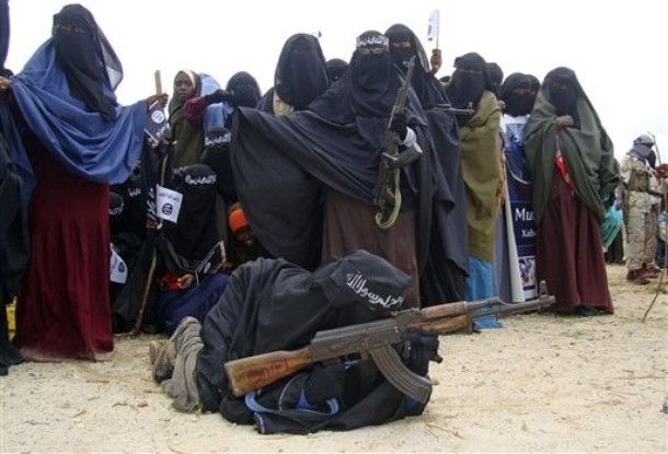 Somali women carry weapons during a demonstration in Suqa Holaha neighborhood in Mogadishu, Somalia, Monday, July 5, 2010. The demonstration was organized by the islamist  Al-Shabaab group which is fighting the Somali government. The demonstrators were carrying placards written with slogans against the African Union peace keeping force. (AP Photo/Mohamed Sheikh Nor)