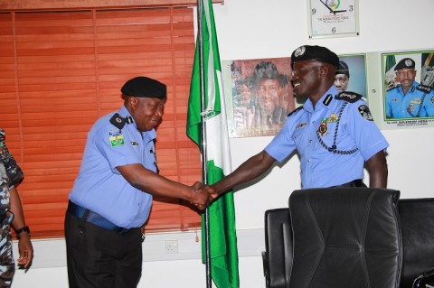 CP Dan Bature receiving a congratulatory hand shake from the IGP after he was decorated with his new rank as Commissioner of Police.