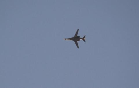 A jet from the U.S.-led coalition flies in the sky over the Syrian town of Kobani as seen from a hill in Tal-Hajeb village that overlooks Kobani, October 7, 2014.