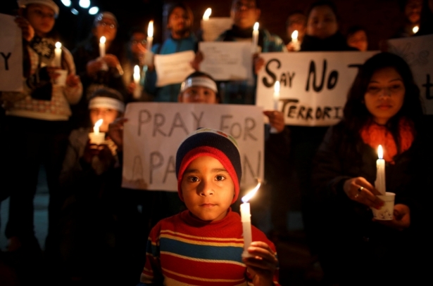 A boy holding a candle attends a candle light vigil in Kathmandu, December 17, 2014, for the students killed at the military-run Army Public School in Peshawar. Pakistan woke up to a day of mourning on Wednesday after Taliban militants killed 132 students in a grisly attack which shocked the nation and put pressure on the government to do more to tackle the insurgency.