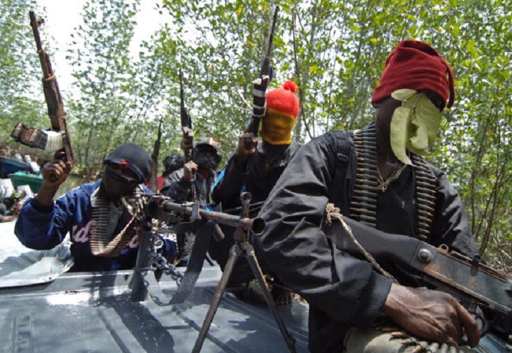 Okrika, NIGERIA: Masked Ateke Tom militants hold their guns as they arrive at their camp, 13 April 2007, in Okrika, Rivers State. Ateke Tom is the leader of the Niger Delta Vigilante, an ethnic Ijaw militia in the Niger Delta region of Nigeria. Many militant groups in the delta say they are fighting for the control of government oil wells. Five people, including a senior police officer, were killed in clashes between rival cult gangs in southern Nigeria's oil-rich state of Rivers, the police said today.    AFP PHOTO / LIONEL HEALING (Photo credit should read LIONEL HEALING/AFP/Getty Images)